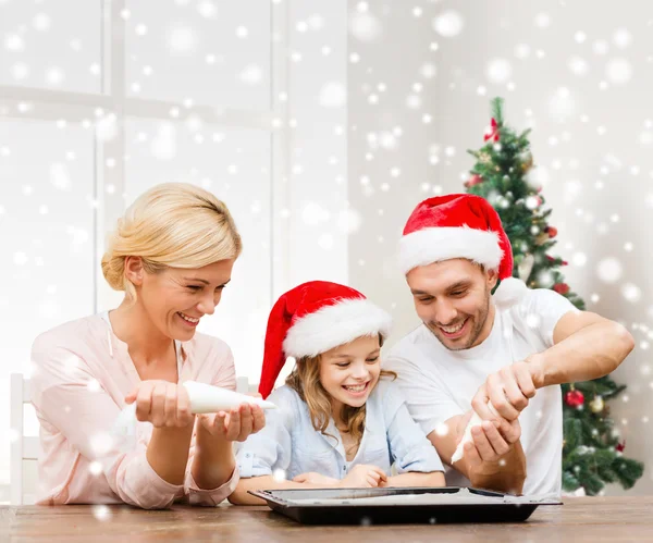 Lycklig familj i santa helper hattar matlagning — Stockfoto