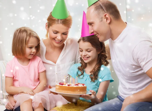 Familia feliz con dos niños en sombreros de fiesta en casa —  Fotos de Stock