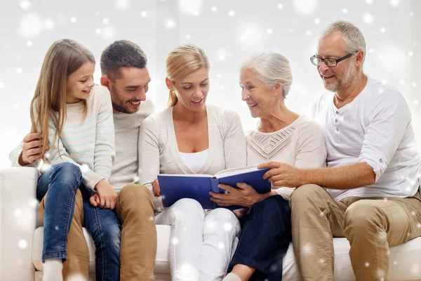 Famiglia felice con libro o album fotografico a casa — Foto Stock