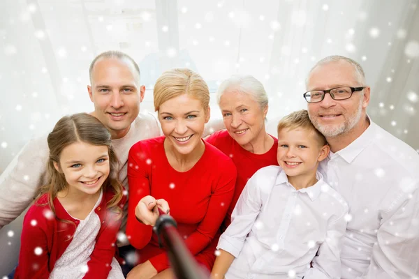 Família sorrindo com vara de selfie fotografando — Fotografia de Stock