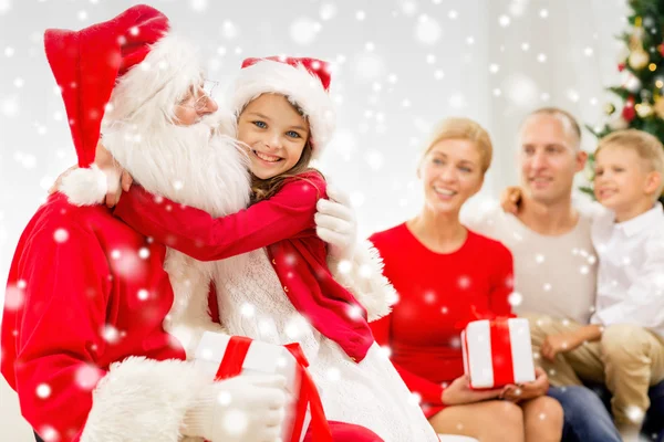 Família sorridente com Papai Noel e presentes em casa — Fotografia de Stock