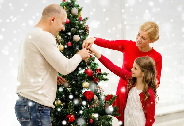 Lächelnde Familie schmückt Weihnachtsbaum zu Hause — Stockfoto