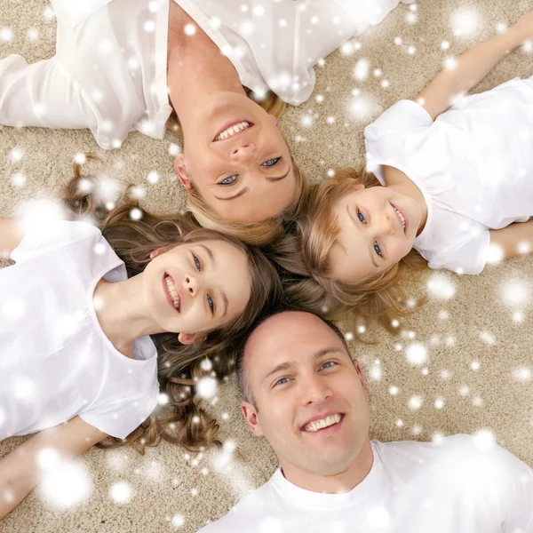 Parents and two girls lying on floor at home Stock Photo