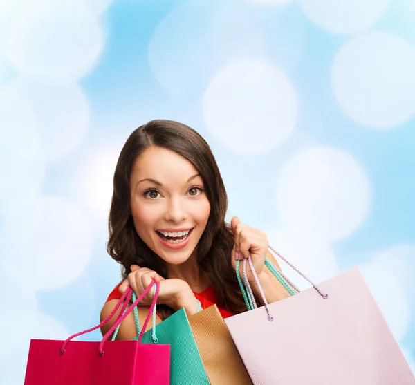 Usmívající se žena s barevnými nákupní tašky — Stock fotografie