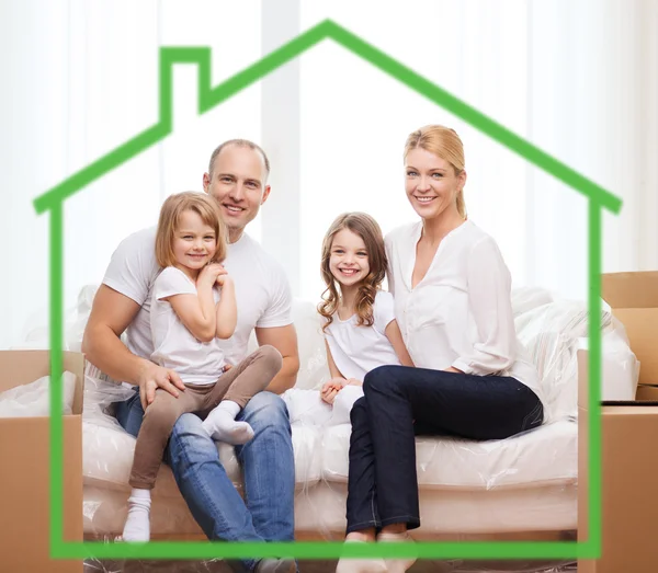 Parents souriants et deux petites filles à la nouvelle maison — Photo