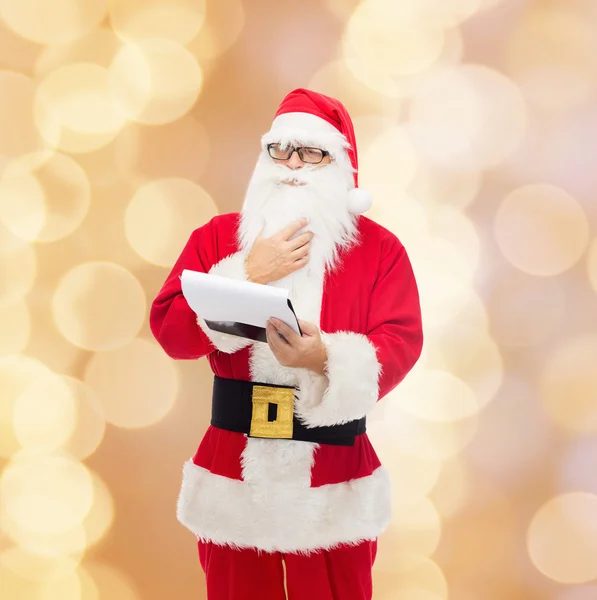 Man in costume of santa claus with notepad — Stock Photo, Image