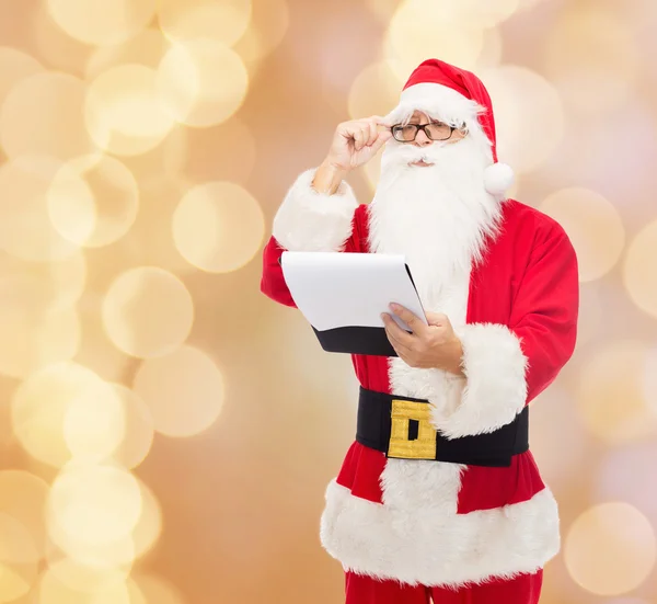 Homem em traje de santa claus com bloco de notas — Fotografia de Stock