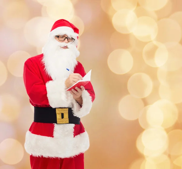 Homme en costume de Père Noël claus avec bloc-notes — Photo