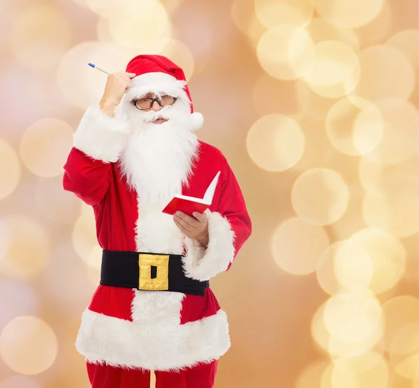 Homme en costume de Père Noël claus avec bloc-notes — Photo