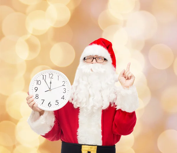 Человек в костюме Санта-Клауса с часами — стоковое фото