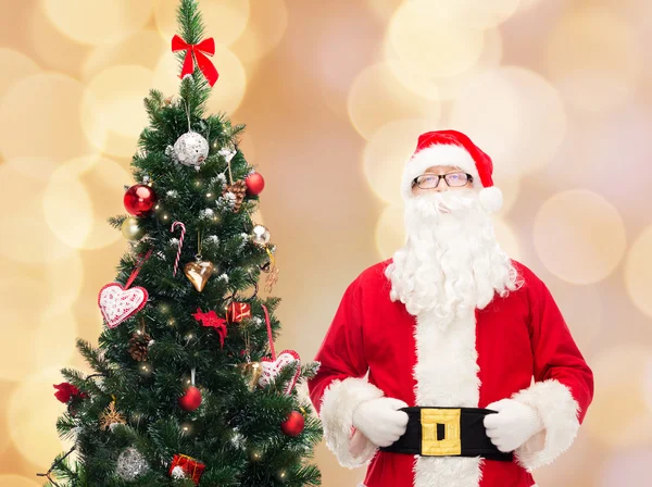 Man in costume of santa claus with christmas tree — Stock Photo, Image