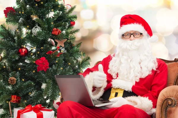 Man in kostuum van de kerstman met laptop — Stockfoto