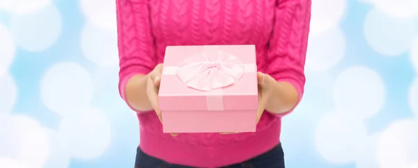 Primer plano de la mujer en suéter rosa celebración caja de regalo — Foto de Stock