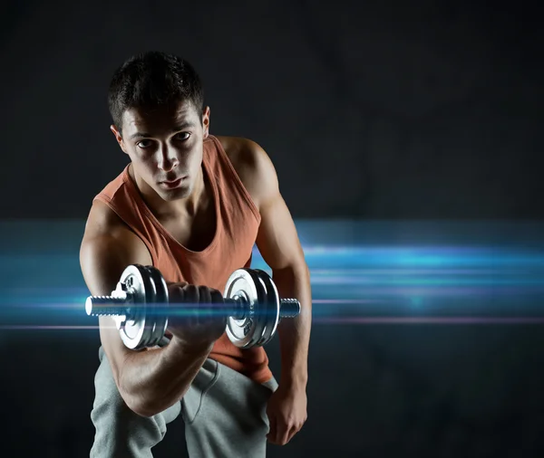 Young man with dumbbell flexing biceps — Stock Photo, Image