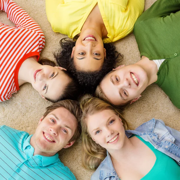 Grupo de personas sonrientes tumbadas en el suelo — Foto de Stock