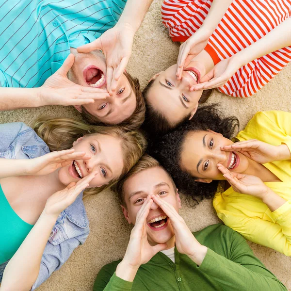 Sorrindo as pessoas deitadas no chão e gritando — Fotografia de Stock