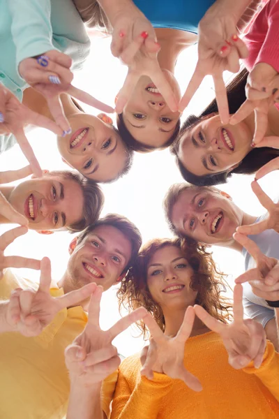 Groupe d'adolescents souriants montrant signe de victoire — Photo