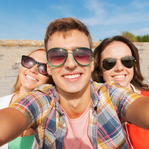 Skupina s úsměvem přátel s selfie venku — Stock fotografie