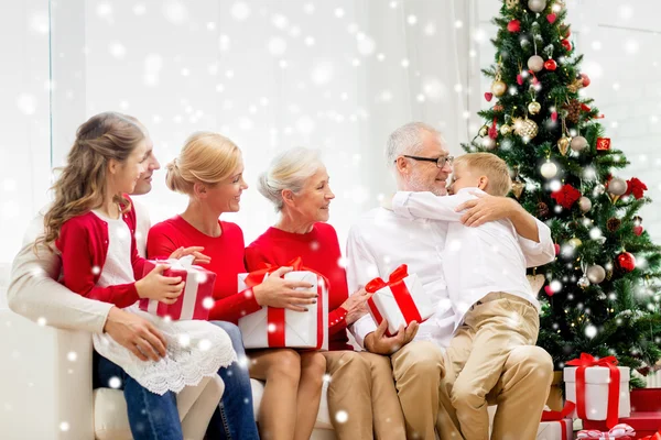 Lachende familie met geschenken thuis knuffelen — Stockfoto