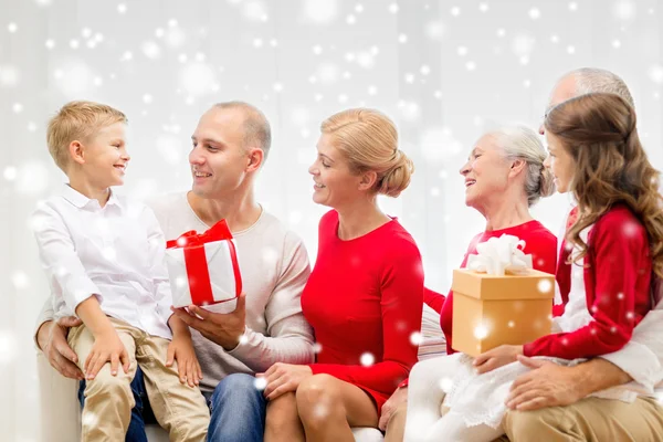 Smiling family with gifts talking at home — Stock Photo, Image
