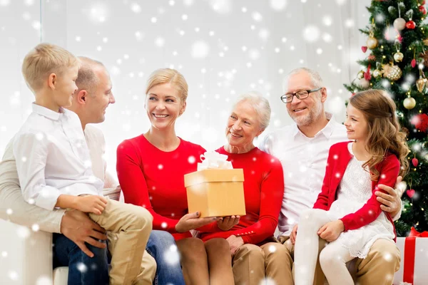 Família sorridente com presente em casa — Fotografia de Stock