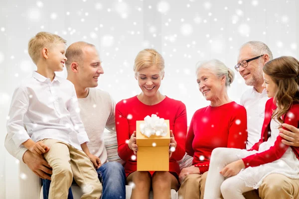 Lachende familie met cadeau thuis — Stockfoto
