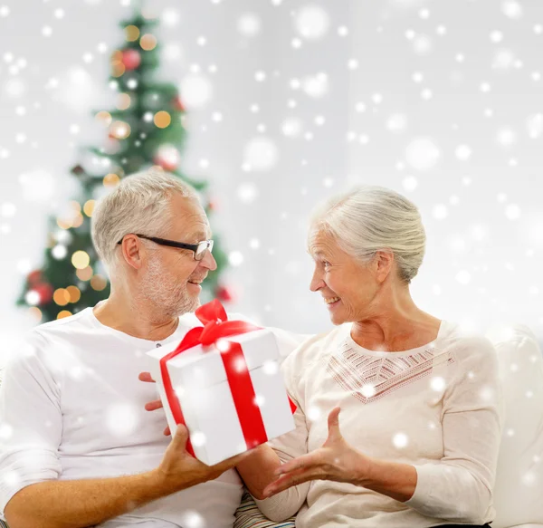 Gelukkig senior paar met geschenkdoos thuis — Stockfoto