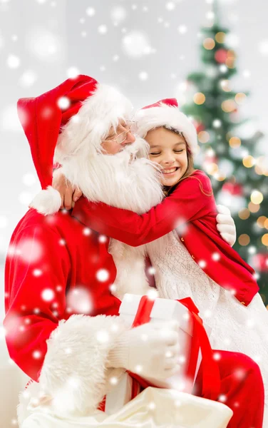 Lachende meisje met santa claus en cadeau thuis — Stockfoto