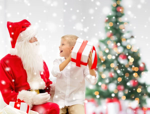 Noel Baba ve hediyeler ile gülümseyen küçük çocuk — Stok fotoğraf