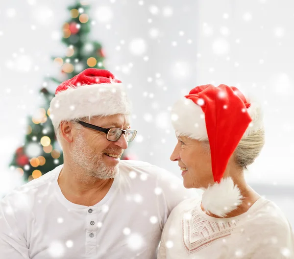 Happy senior couple in santa helper hats at home — Stock Photo, Image