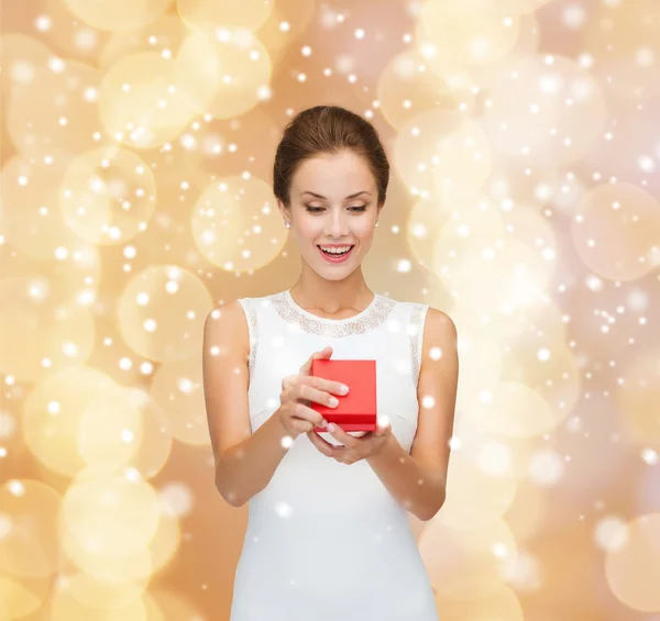 Smiling woman holding red gift box — Stock Photo, Image