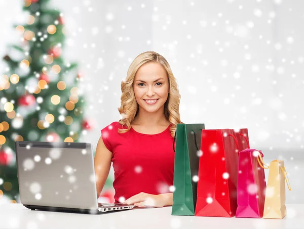 Woman with gift boxes and laptop computer — Stock Photo, Image