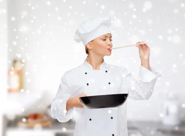 Chef féminin souriant avec casserole et cuillère — Photo