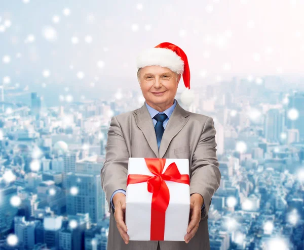 Glimlachende man in pak en santa helper hoed met cadeau — Stockfoto