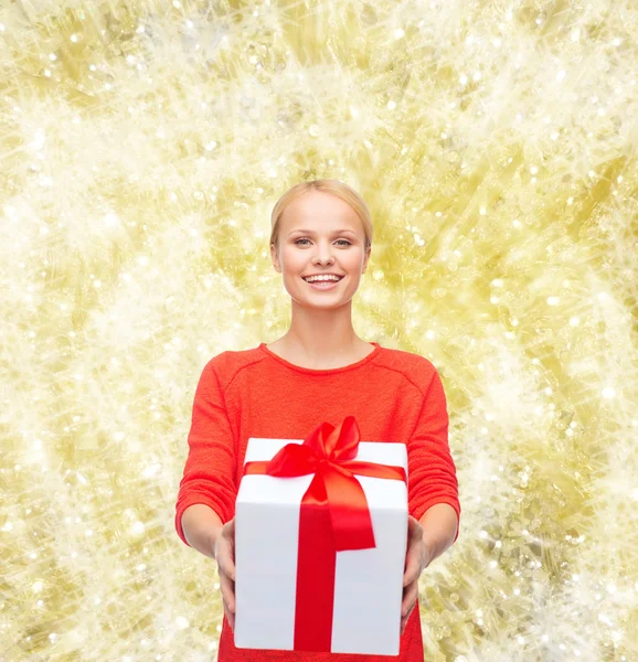 Usmívající se žena v červených šatech s dárkový box — Stock fotografie
