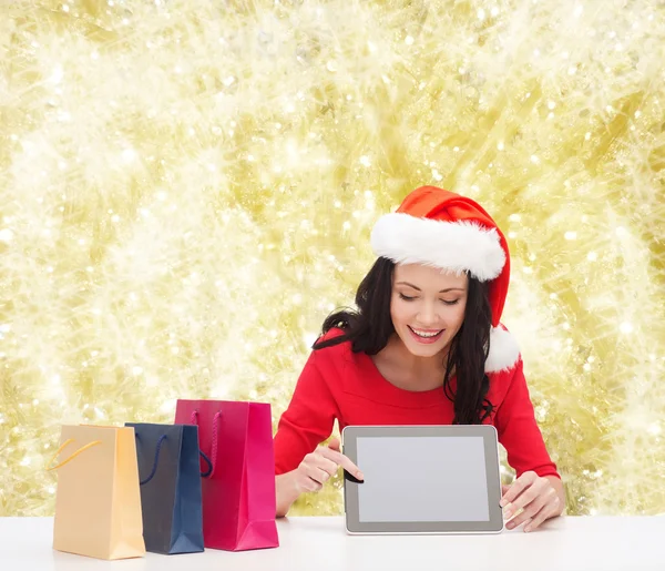 Mulher sorridente com sacos de compras e tablet pc — Fotografia de Stock