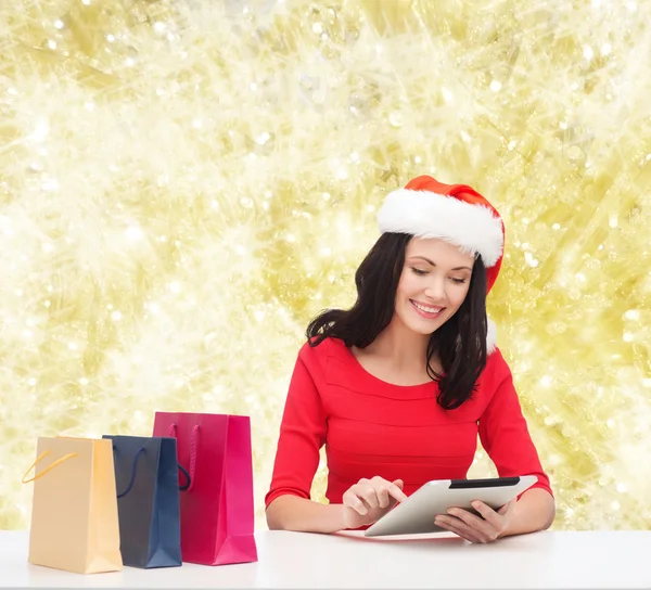 Mulher sorridente com sacos de compras e tablet pc — Fotografia de Stock