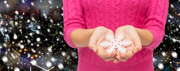 Close up of woman in sweater holding snowflake — Stock Photo, Image