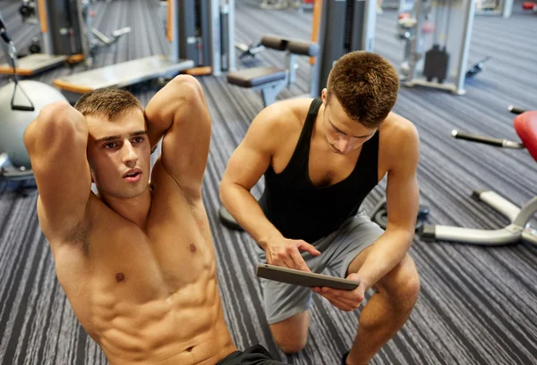Muži protahuje břišní svaly v posilovně — Stock fotografie