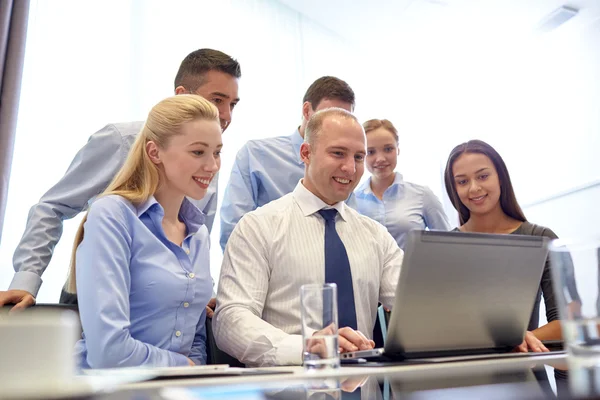 Des hommes d'affaires souriants avec ordinateur portable au bureau — Photo