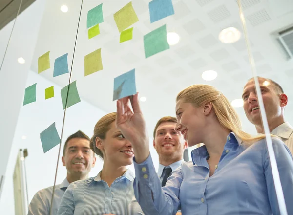 Smiling business people with marker and stickers — Stock Photo, Image