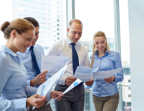 Smiling businesspeople with papers in office — Stock Photo, Image