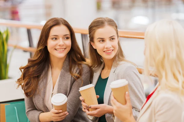 Mulheres jovens com sacos de compras e café no shopping — Fotografia de Stock