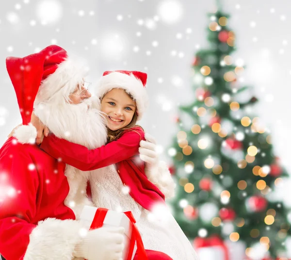 Smiling girl with santa claus and gift at home Stock Image