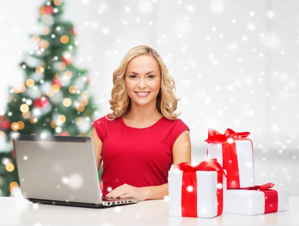 Frau mit Geschenkboxen und Laptop — Stockfoto