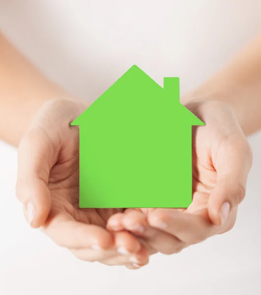 Mãos segurando casa de papel verde — Fotografia de Stock