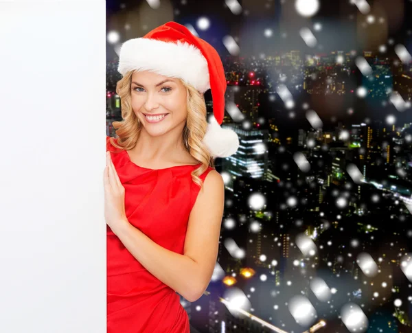 Smiling young woman in santa hat with white board — Stock Photo, Image