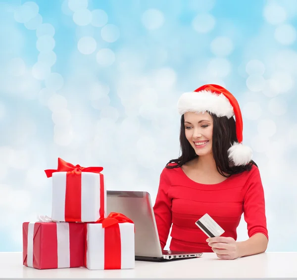 Mujer sonriente con regalos, laptop y tarjeta de crédito —  Fotos de Stock