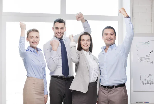 Equipo de negocios celebrando la victoria en el cargo Imágenes de stock libres de derechos