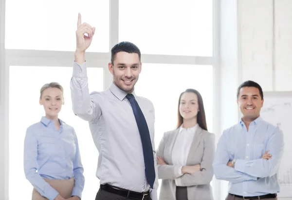 Hombre de negocios sonriente en la oficina con el equipo en la espalda Imagen De Stock